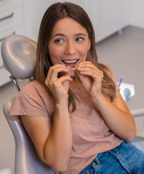 Patient looking at dentist while putting on clear aligner