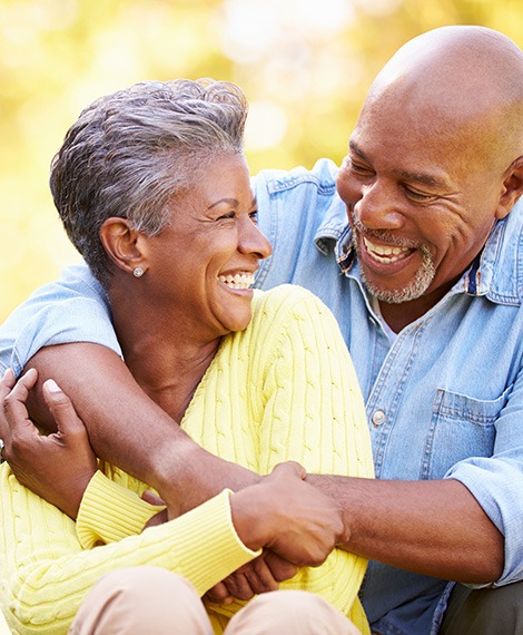 Couple smiling after completing dental implant post-op instructions in Henderson